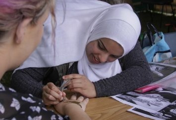 2 people working together smiling. The text underneath reads make a difference