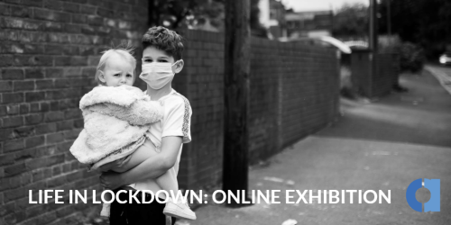 A young person holding a child in a street this image is in black and white and was taken during corona virus. The text underneath reads life in lockdown