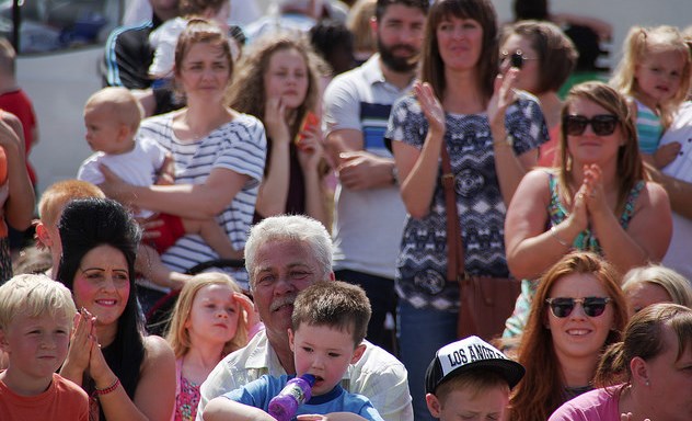 Image of a crowd of families smiling and clapping